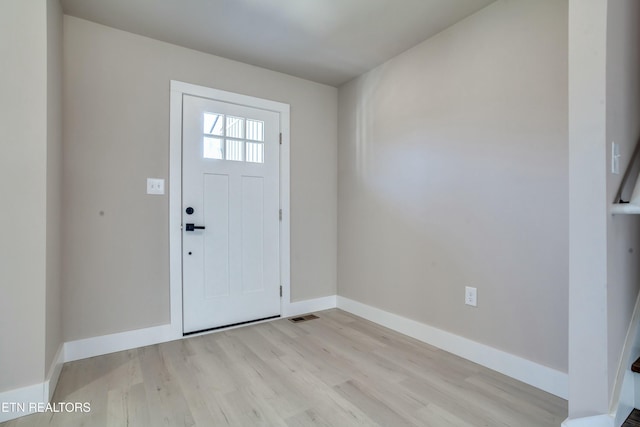 foyer entrance featuring light wood-style flooring and baseboards