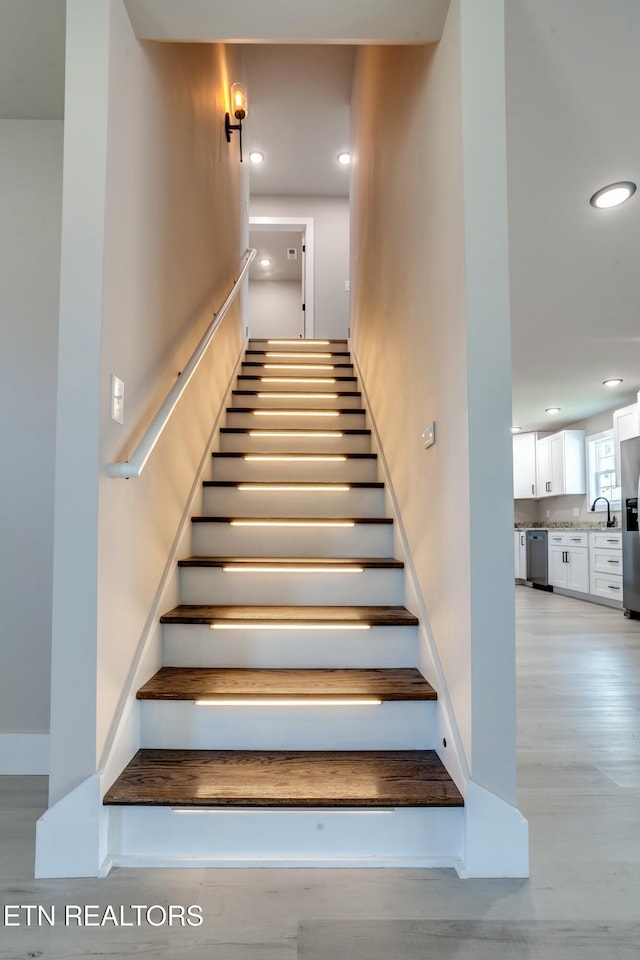 stairs with recessed lighting, baseboards, and wood finished floors