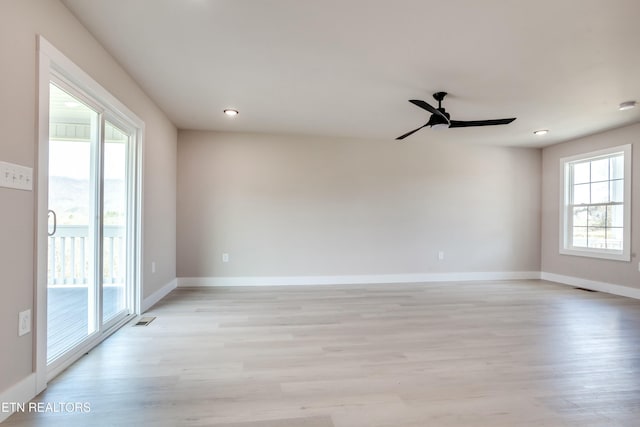 spare room with a wealth of natural light, visible vents, baseboards, and light wood-style floors