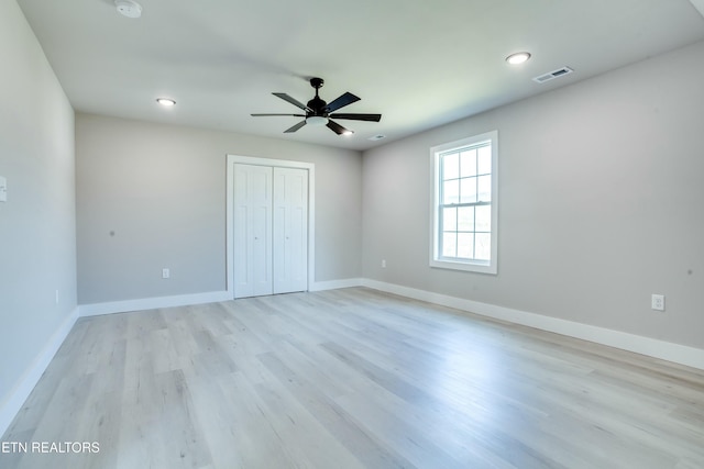 unfurnished bedroom with light wood finished floors, a closet, and baseboards