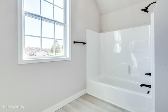 full bath with shower / bath combination, baseboards, and wood finished floors