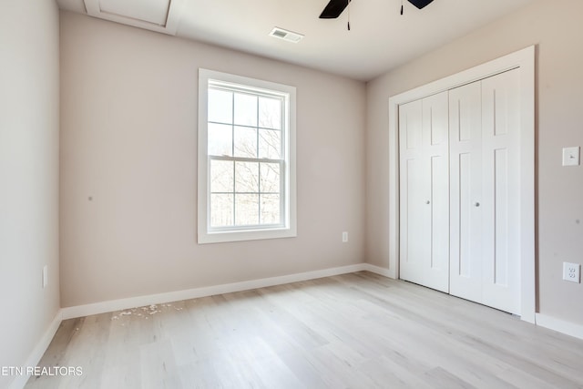 unfurnished bedroom with light wood-type flooring, visible vents, baseboards, and a closet