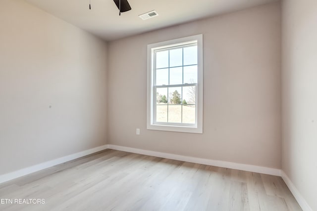 unfurnished room featuring ceiling fan, light wood-style floors, visible vents, and baseboards