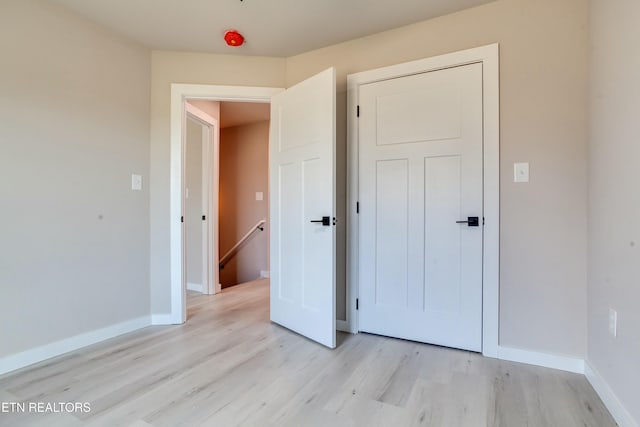 unfurnished bedroom featuring light wood-type flooring and baseboards