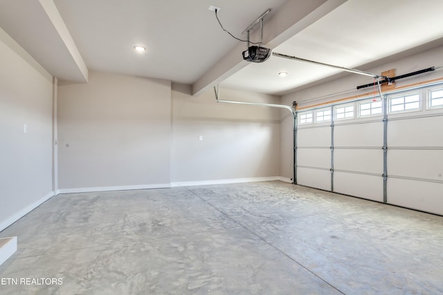 garage featuring a garage door opener and baseboards