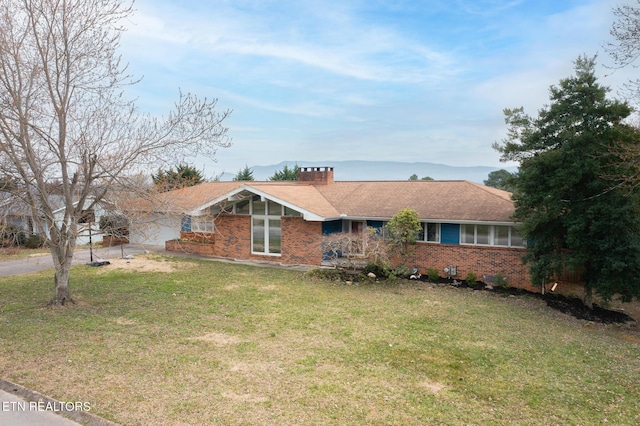 single story home featuring concrete driveway, a garage, brick siding, and a front lawn