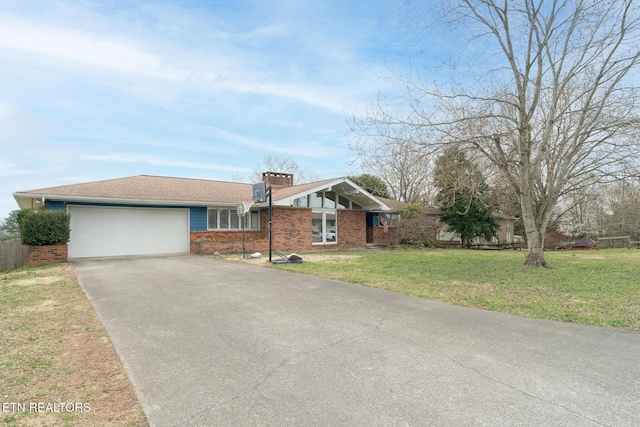 view of front of home with brick siding, a front lawn, concrete driveway, a chimney, and an attached garage