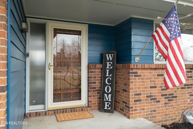 view of exterior entry featuring brick siding