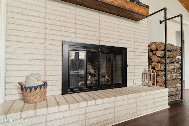 interior details featuring a brick fireplace and wood finished floors