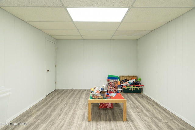 game room featuring baseboards, a paneled ceiling, and wood finished floors