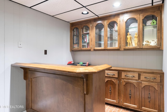 bar with recessed lighting, a paneled ceiling, and brick floor