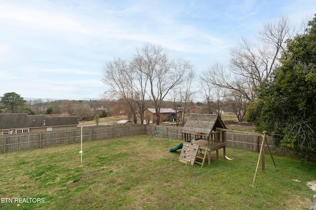 view of yard with a fenced backyard and a playground