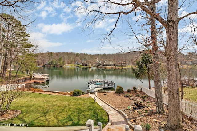 view of dock featuring a yard, fence, and a water view