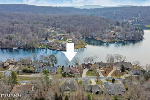 birds eye view of property featuring a forest view, a water view, and a residential view