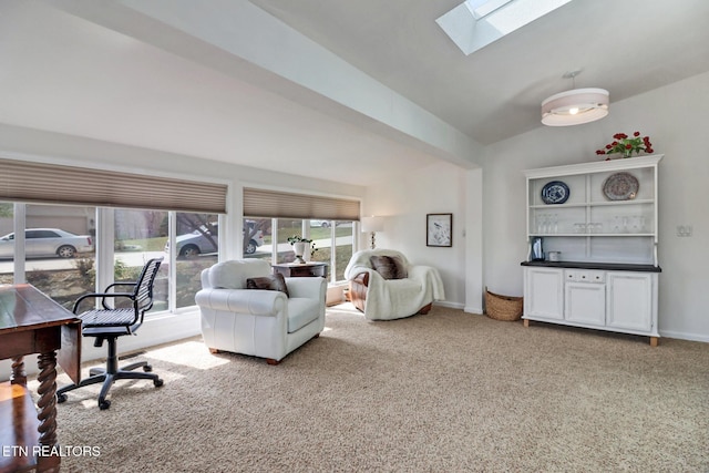 carpeted office space with lofted ceiling with skylight and baseboards