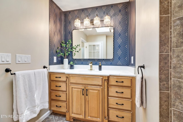 bathroom featuring wallpapered walls and vanity