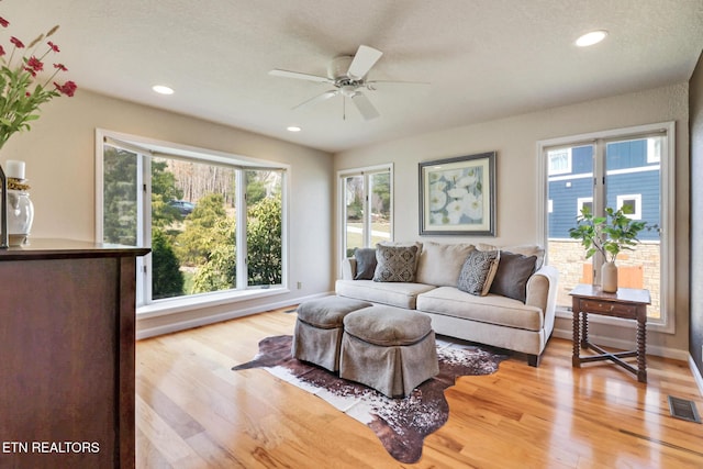 living room with recessed lighting, visible vents, light wood finished floors, and ceiling fan