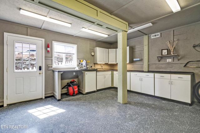 kitchen with visible vents, dark countertops, dark speckled floor, and white cabinetry