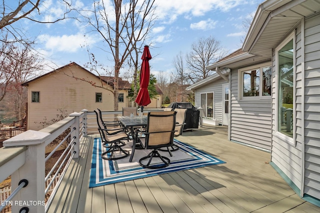 wooden deck with area for grilling and outdoor dining area