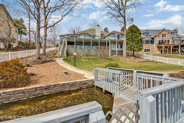 back of house featuring a residential view, a lawn, stairs, and a fenced backyard