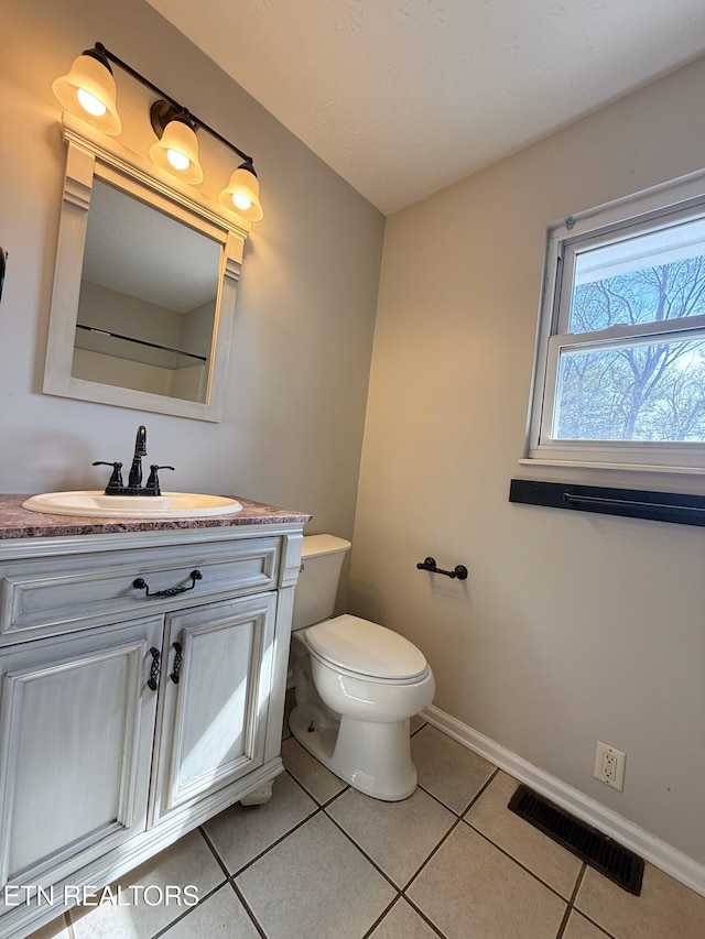 bathroom with tile patterned flooring, visible vents, baseboards, toilet, and vanity