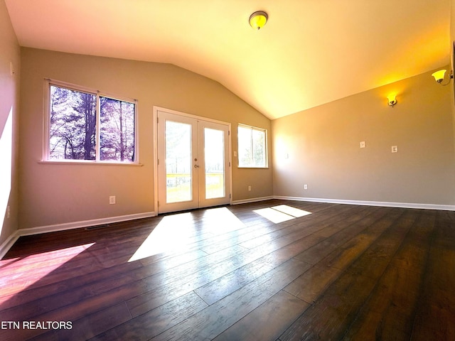 spare room featuring french doors, lofted ceiling, dark wood-type flooring, and baseboards