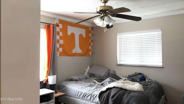 bedroom with ceiling fan, a textured ceiling, and ornamental molding