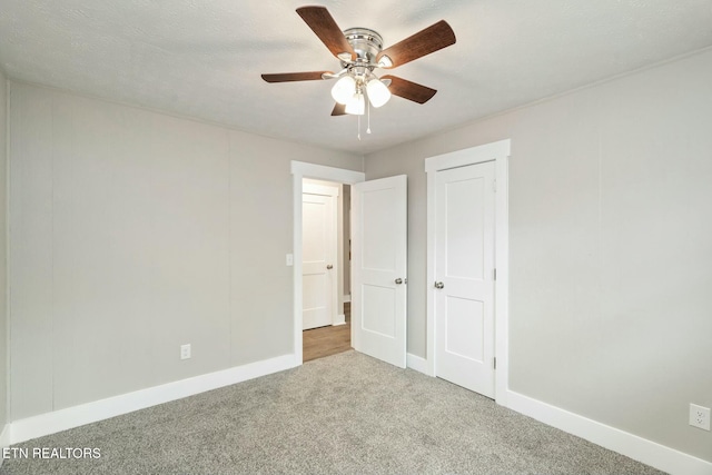 unfurnished bedroom with baseboards, carpet floors, and ceiling fan