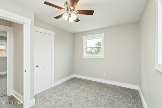 unfurnished bedroom with baseboards, carpet floors, and a ceiling fan