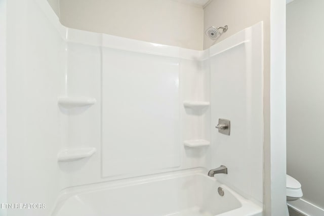 bathroom featuring tub / shower combination and toilet