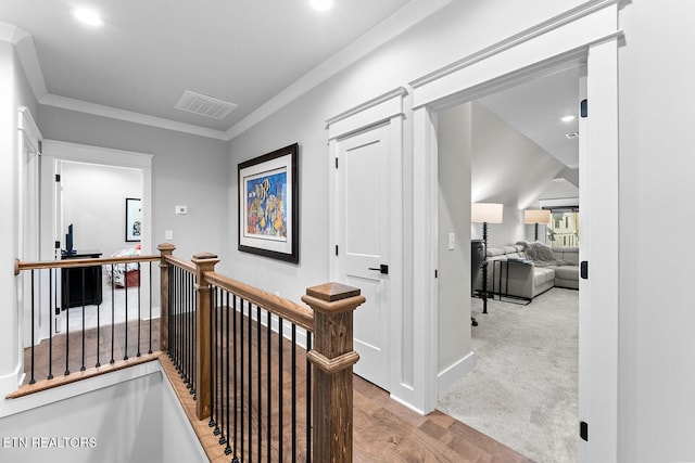 hall featuring visible vents, an upstairs landing, ornamental molding, wood finished floors, and recessed lighting