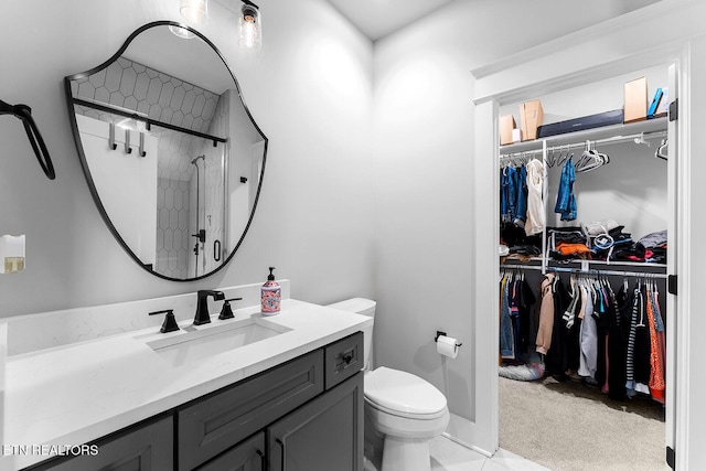 full bathroom with a shower stall, vanity, toilet, and a walk in closet