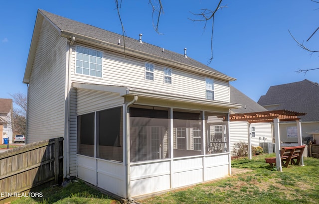 rear view of house with a pergola, a shingled roof, a sunroom, and fence