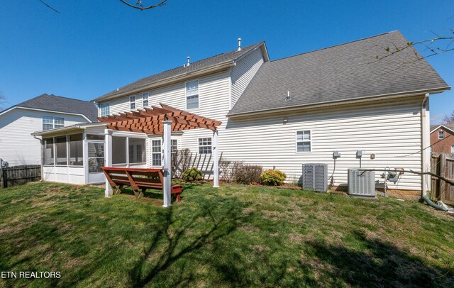 rear view of house with cooling unit, a sunroom, fence, a pergola, and a yard