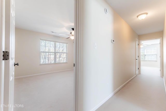 hall with baseboards and carpet