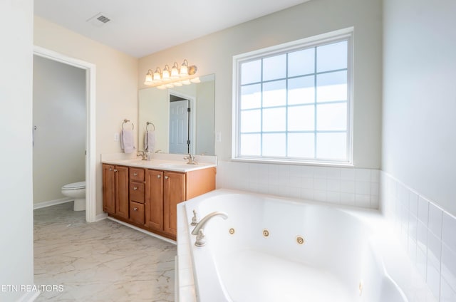 full bathroom with toilet, a tub with jets, marble finish floor, visible vents, and double vanity