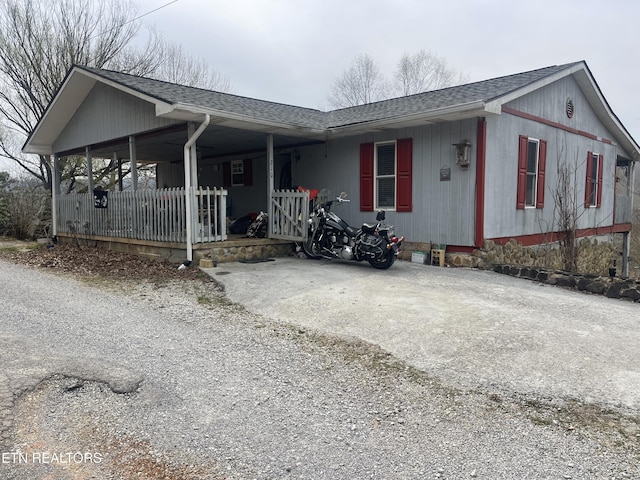 single story home featuring covered porch and a shingled roof