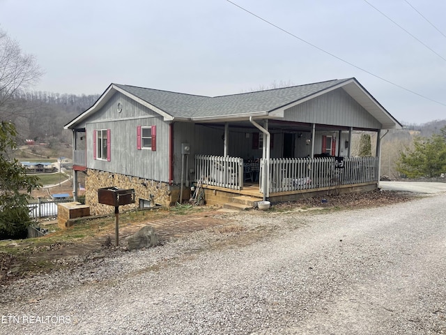 view of front of house with roof with shingles and a porch