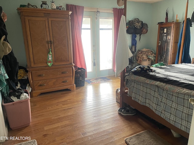 bedroom with french doors and light wood-style floors