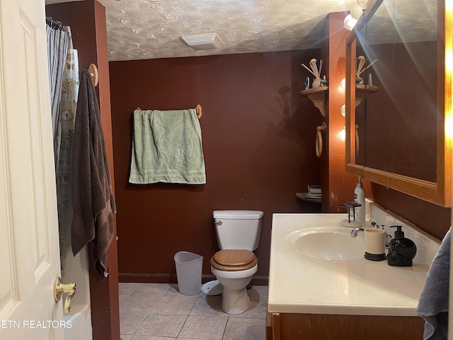 bathroom featuring tile patterned flooring, visible vents, toilet, vanity, and a textured ceiling