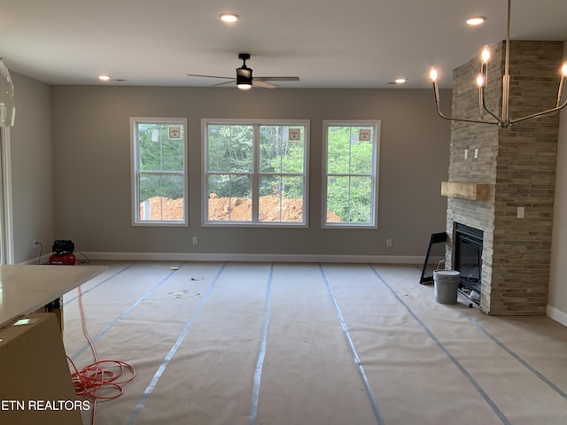 unfurnished living room featuring recessed lighting, a ceiling fan, a stone fireplace, and baseboards