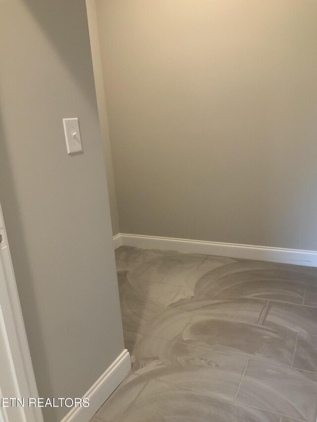 unfurnished room featuring baseboards