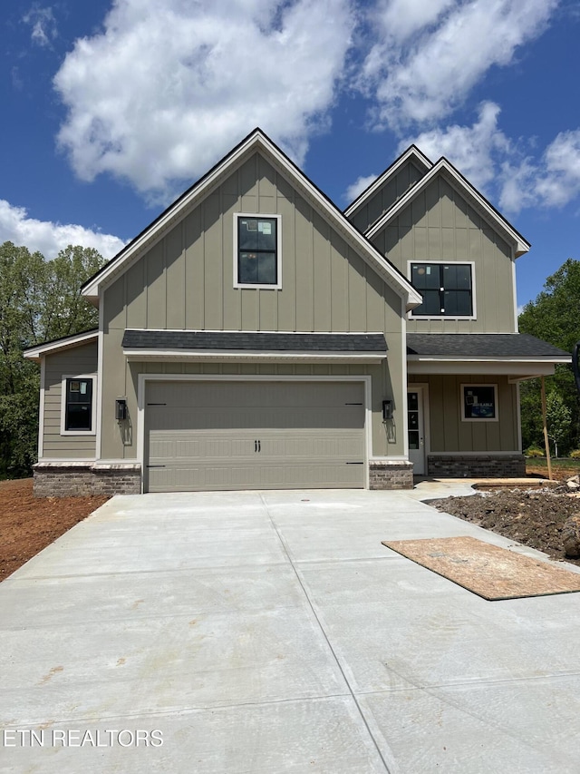 craftsman-style home featuring concrete driveway, board and batten siding, and roof with shingles