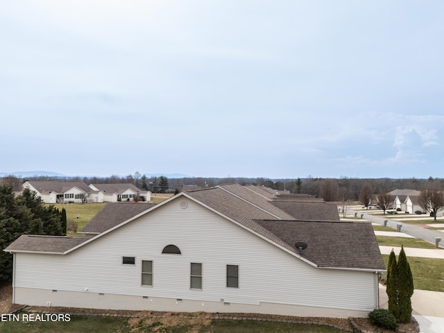 exterior space featuring a residential view and a shingled roof