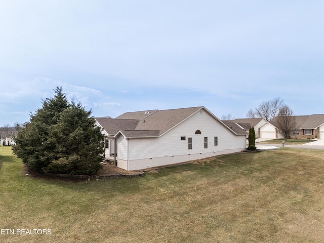 view of side of home with crawl space, a lawn, driveway, and a garage