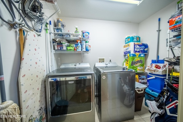 laundry room with laundry area, light tile patterned flooring, and washing machine and clothes dryer