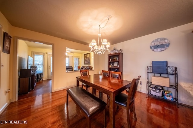 dining area featuring a notable chandelier, wood finished floors, and baseboards