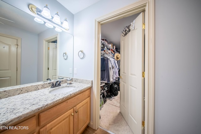 bathroom featuring vanity and a walk in closet