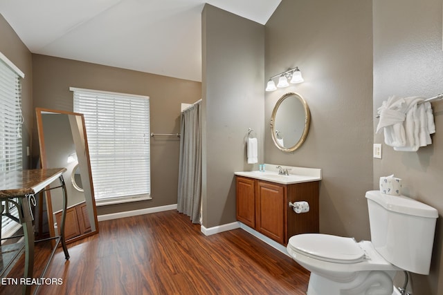 bathroom featuring a wealth of natural light, toilet, baseboards, and wood finished floors