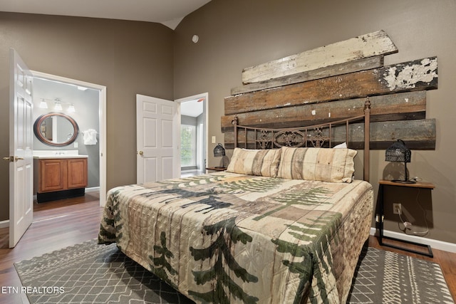 bedroom featuring baseboards, high vaulted ceiling, and wood finished floors